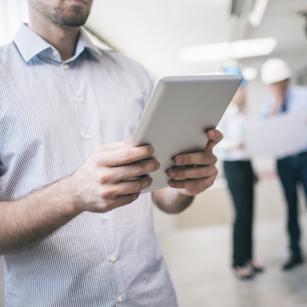 An engineer checking construction plans on digital tablet on construction site