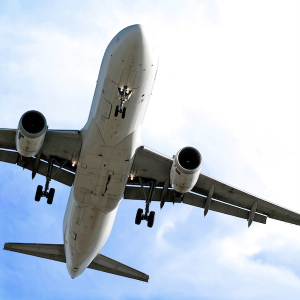 jet airplane in close-up landing in bright cloudy sky, square frame